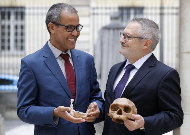 French paleoanthropologist Jean-Jacques Hublin (R) and Abdelouahed Ben-Ncer of the National Institute of Archaeology and Heritage Sciences in Morocco pose with the casting of a skull of Homo Sapiens discovered in Morocco on June 6, 2017 in Paris. (AFP Photo)