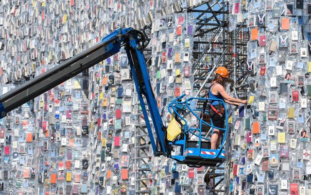 A volunteer uses a mobile lift to hang books on "The Parthenon of Books". (AFP/John Macdougall) A volunteer uses a mobile lift to hang books on "The Parthenon of Books". (AFP/John Macdougall)