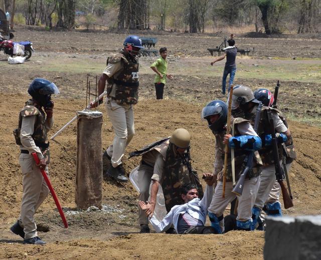 Policemen wrestle an agitating farmer into submission. (HT Photo)