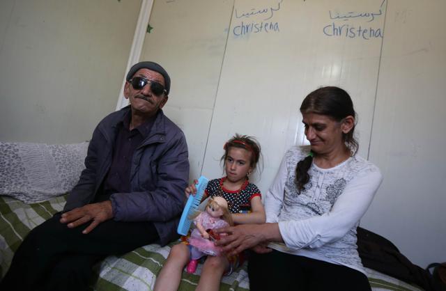 Christena with her father and mother in Ashti 2 camp for displaced Christians in Arbil. (AFP) Christena with her father and mother in Ashti 2 camp for displaced Christians in Arbil. (AFP)