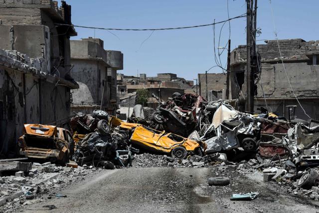 Damaged cars are seen stacked in the middle of a road in western Mosul's Zanjili neighbourhood on June 9, 2017, during ongoing battles to try to take the city from Islamic State (IS) group fighters. (AFP Photo)