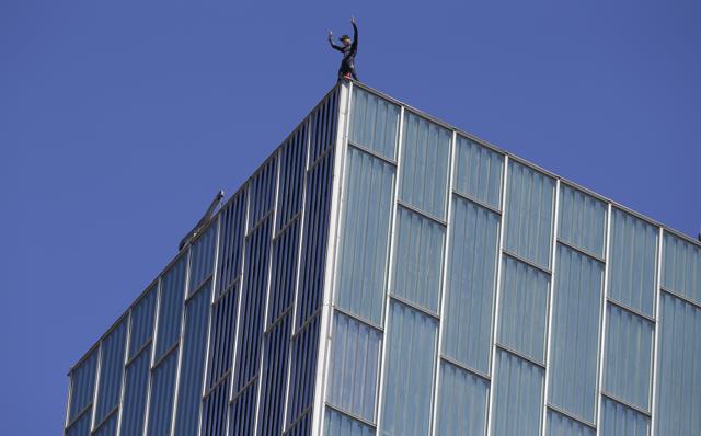 French urban climber, Alain Robert gestures after scaling the 120 meters Melia Barcelona Sky Hotel. (AP Photo)