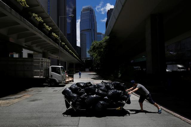 A worker pushes a cart loaded with garbage collected nearby to a refuse collection point at the financial Central District in Hong Kong. (Reuters Photo) A worker pushes a cart loaded with garbage collected nearby to a refuse collection point at the financial Central District in Hong Kong. (Reuters Photo)