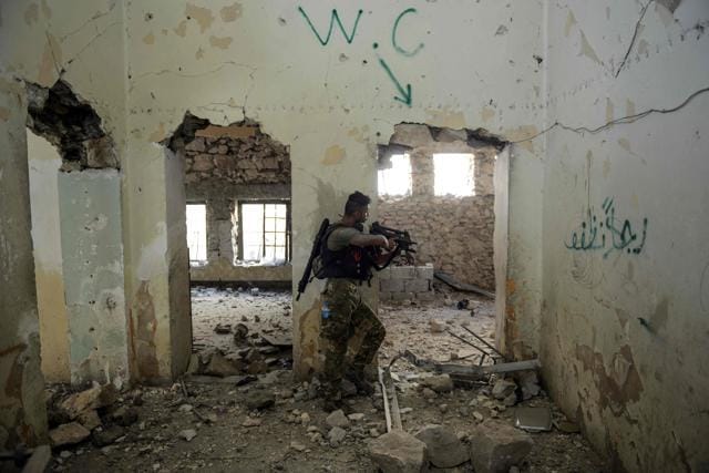 An Iraqi elite Rapid Response Division member aims his gun towards Islamic State fighters inside a building in Mosul's western Al-Shifa district on June 12, 2017. (AFP) An Iraqi elite Rapid Response Division member aims his gun towards Islamic State fighters inside a building in Mosul's western Al-Shifa district on June 12, 2017. (AFP)