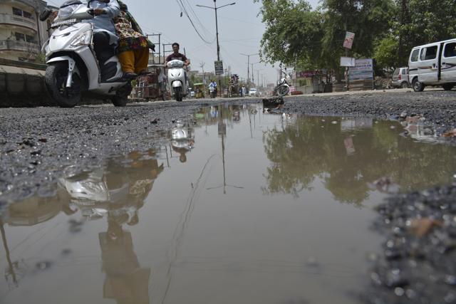 Water stagnates in a pothole-riddled stretch in Shalimar Garden, Ghaziabad, on Wednesday. (Sakib Ali /HT Photo)