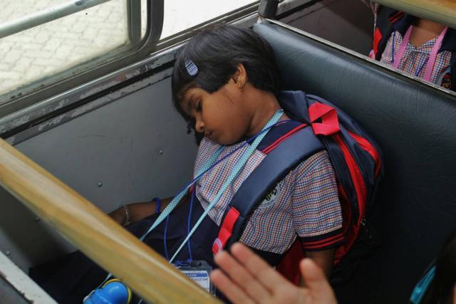 A girl takes a nap on her way to school on the school bus. (Praful gangurde)