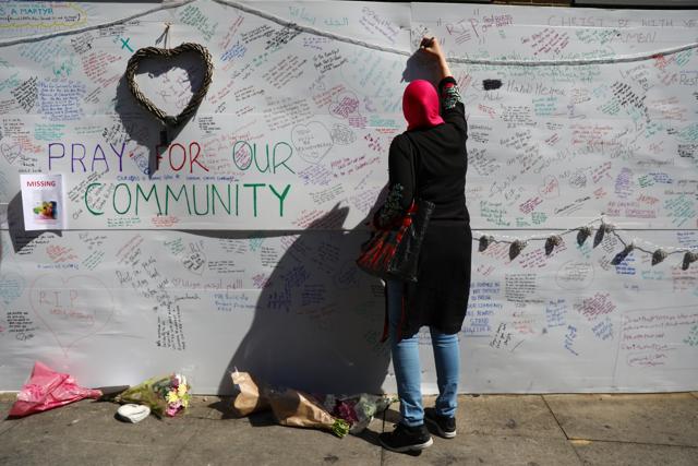 A woman writes on a message wall near Grenfell Tower. (Reuters) A woman writes on a message wall near Grenfell Tower. (Reuters)