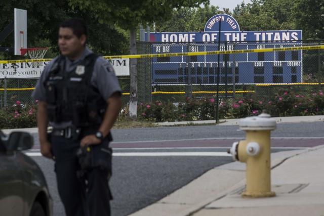 A police officer stands near Eugene Simpson Field, the site where a gunman opened fire. (AFP Photo)