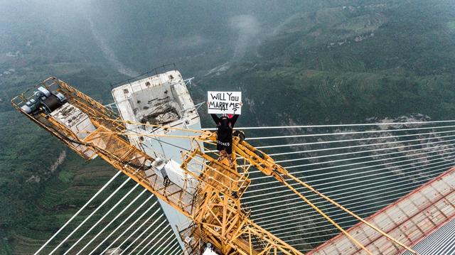 He climbed the 1853 foot Beipanjiang Bridge in China, one of the tallest in the world, holding a placard saying “Will You Marry Me?” (Keow Wee Loong Facebook) (readers are advised not to repeat this at home) He climbed the 1853 foot Beipanjiang Bridge in China, one of the tallest in the world, holding a placard saying “Will You Marry Me?” (Keow Wee Loong Facebook) (readers are advised not to repeat this at home)
