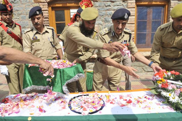 Policeman shower flower petals on the coffin of Tasveer Ahamad during the wreath-laying ceremony on Saturday at the police headquarters in Srinagar. Ahamad was among the six policemen who were killed in a militant attack on Friday. (Waseem Andrabi/HT photo)