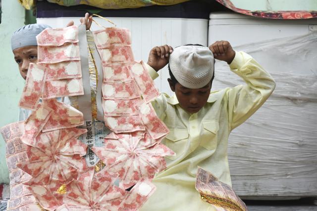 Amaan and Mohd Zaid play with garlands of currency notes during a celebration of the first Ramzan fast of their lives. (Saumya Khandelwal/HT Photo) Amaan and Mohd Zaid play with garlands of currency notes during a celebration of the first Ramzan fast of their lives. (Saumya Khandelwal/HT Photo)