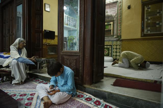 Badar Jehan, 85 year old looks at her son as he offers the post-iftar namaz, and her grandson engrossed in a cellphone at their home in Old Delhi. (Saumya Khandelwal/HT Photo) Badar Jehan, 85 year old looks at her son as he offers the post-iftar namaz, and her grandson engrossed in a cellphone at their home in Old Delhi. (Saumya Khandelwal/HT Photo)