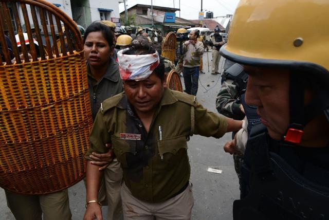 An injured cop is helped by colleagues during clashes with supporters of the Gorkha Janmukti Morcha (GJM) group in Darjeeling. (AFP Photo) An injured cop is helped by colleagues during clashes with supporters of the Gorkha Janmukti Morcha (GJM) group in Darjeeling. (AFP Photo)