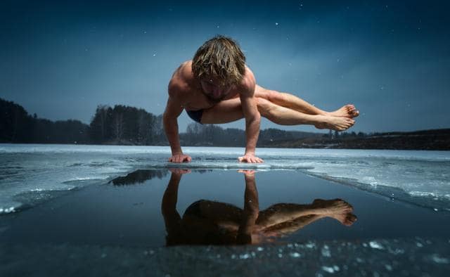 Man doing yoga (parsva bakasana) on a frozen lake. (Shutterstock)