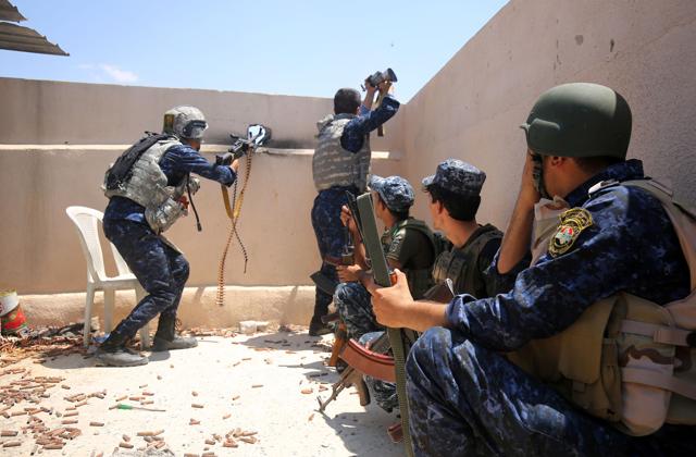 Iraqi forces take a position on the roof of a building as they advance towards Mosul's Old City on June 18, 2017. (AFP Photo) Iraqi forces take a position on the roof of a building as they advance towards Mosul's Old City on June 18, 2017. (AFP Photo)