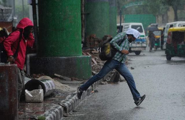 A man crosses a water logged road at Govindpuri. (Burhaan Kinu / HT Photo) A man crosses a water logged road at Govindpuri. (Burhaan Kinu / HT Photo)
