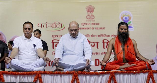 National President of BJP Amit Shah (C), Gujarat Chief Minister Vijay Rupani (L) and Yoga guru Baba Ramdev perform Yoga on 3rd International Yoga Day at GMDC ground in Ahmedabad on June 21, 2017. (PTI)