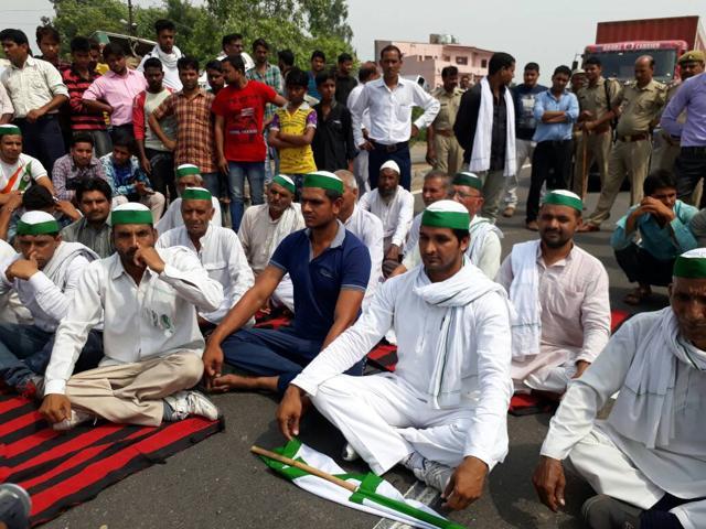 Farmers perform yoga on the Delhi-Dehradun highway in Daurala town of Meerut on Wednesday morning as a symbolic protest on International Yoga Day. (Chahatram/HT Photo)