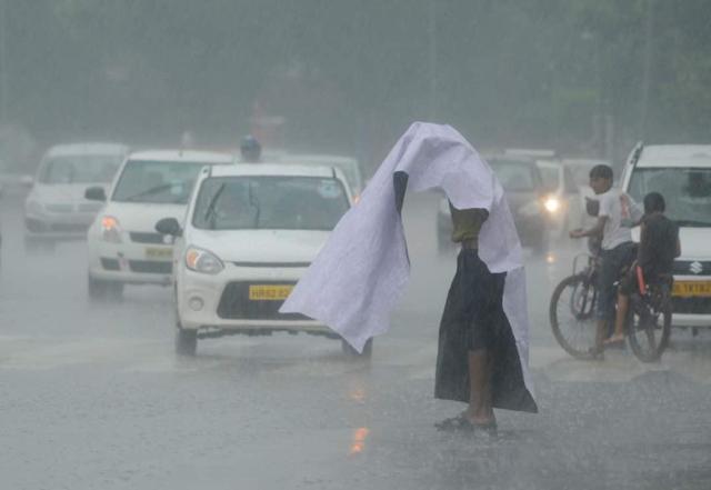 A man takes covers himself as the city receives a heavy bout of showers on Wednesday afternoon. The traffic remained heavy in areas in south, west and east Delhi. (Burhaan Kinu / HT Photo) A man takes covers himself as the city receives a heavy bout of showers on Wednesday afternoon. The traffic remained heavy in areas in south, west and east Delhi. (Burhaan Kinu / HT Photo)