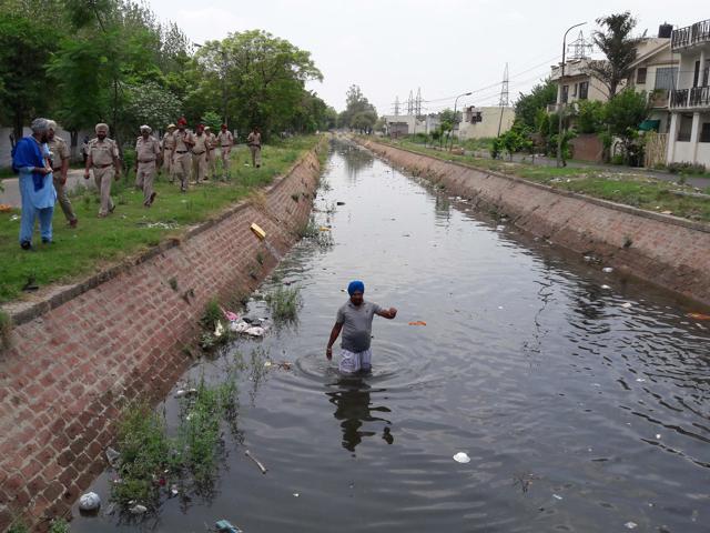 A local resident searching for the torn pages of Gutka Sahib. (Pardeep Pandit/HT)