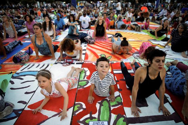 People practice yoga in Tel Aviv on June 21, 2017. (REUTERS) People practice yoga in Tel Aviv on June 21, 2017. (REUTERS)