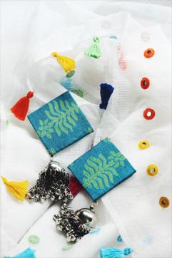 A pair of earrings by Jasmine Kaur, crafted from surplus cloth. A pair of earrings by Jasmine Kaur, crafted from surplus cloth.