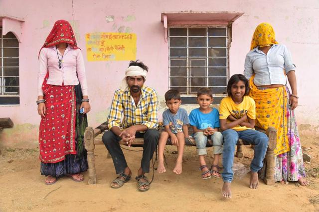 A family sits near the official writing on the wall outside their home in Dausa. (Prabhakar Sharma / HT Photo) A family sits near the official writing on the wall outside their home in Dausa. (Prabhakar Sharma / HT Photo)