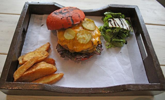 The tenderloin burger, was messy but more satisfying, a plump, rosemary-infused buffalo patty inside a beetroot-reddened bun, slathered with gooey melted cheese. (Satyabrata Tripathy/ HT Photo)