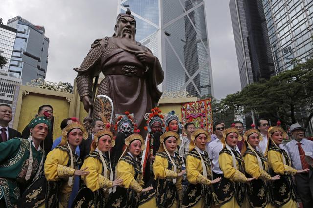 Performers pose for photographers in front of the 20 feet tall bronze statue of Guan Gong, a Chinese God of War, in Hong Kong on Saturday, ahead of the 20th anniversary of the city’s handover to China. Guan Gong, who is the historical figure of general Guan Yu, is widely regarded as a symbol of loyalty and integrity. (AP) Performers pose for photographers in front of the 20 feet tall bronze statue of Guan Gong, a Chinese God of War, in Hong Kong on Saturday, ahead of the 20th anniversary of the city’s handover to China. Guan Gong, who is the historical figure of general Guan Yu, is widely regarded as a symbol of loyalty and integrity. (AP)