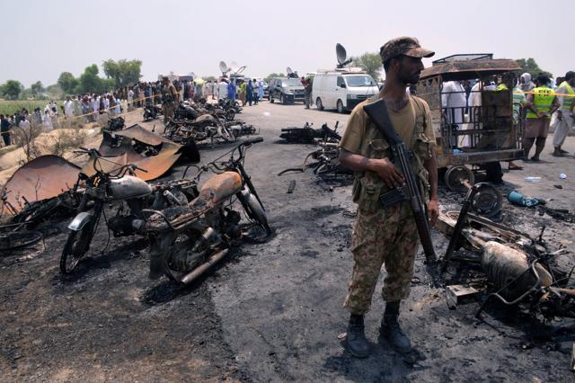 A soldier stands guard amid burnt out cars and motorcycles at the scene of the oil tanker explosion in Bahawalpur in Pakistan. (REUTERS) A soldier stands guard amid burnt out cars and motorcycles at the scene of the oil tanker explosion in Bahawalpur in Pakistan. (REUTERS)