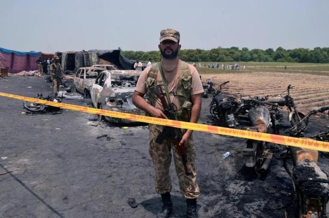 A soldier stands guard at the scene of the oil tanker explosion in Bahawalpur in Pakistan. (REUTERS) A soldier stands guard at the scene of the oil tanker explosion in Bahawalpur in Pakistan. (REUTERS)