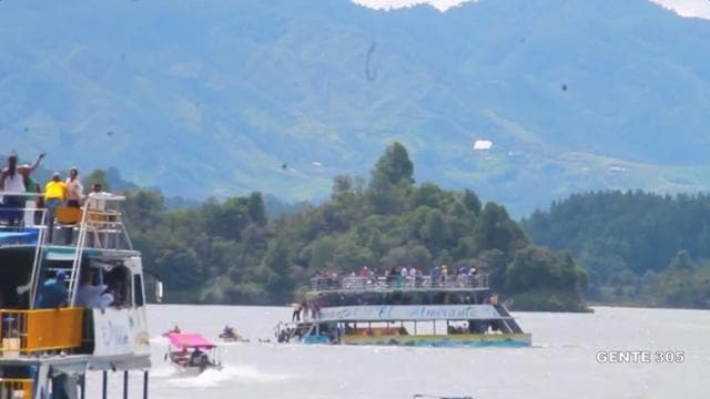A tourist ferry sinks in the Guatape reservoir in Colombia on Sunday in this still image taken from video obtained from social media. (Reuters) A tourist ferry sinks in the Guatape reservoir in Colombia on Sunday in this still image taken from video obtained from social media. (Reuters)