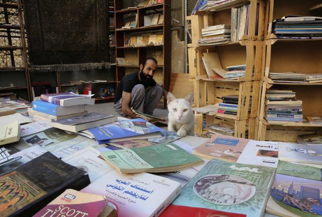 AlMaaytah sorts books at his Mahall al-Maa bookstore. (AP) AlMaaytah sorts books at his Mahall al-Maa bookstore. (AP)