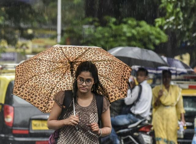 A college-goer braves the rain at GTB Nagar. (Kunal Patil/Hindustan Times)