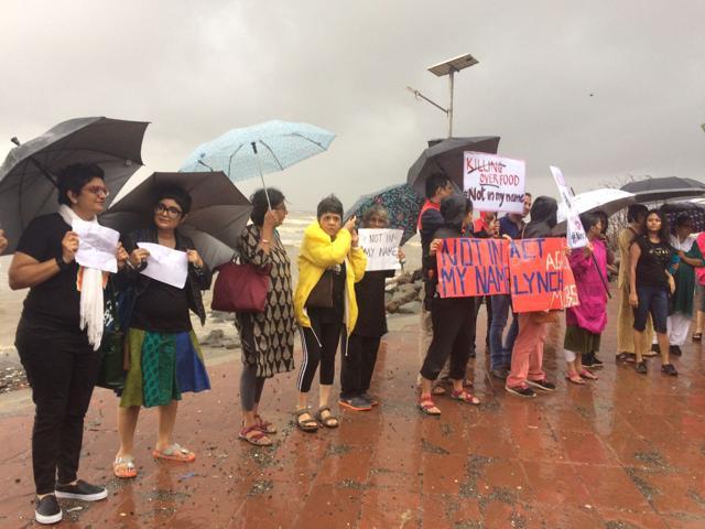 Protesters stand in the rain at Carter Road in Mumbai. (HT) Protesters stand in the rain at Carter Road in Mumbai. (HT)