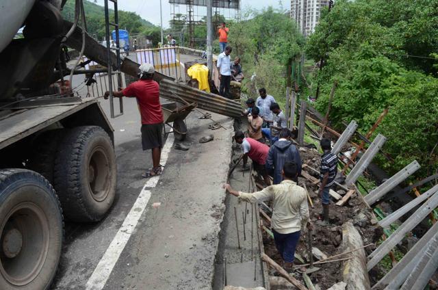 Civic officials repairing a portion of the approach road near Patripool bridge in Kalyan. (HT Photo)