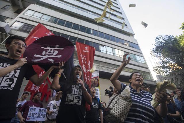 Pro-democracy activists try to march with a replica of a casket with the word meaning "Respect for the dead" towards the venue where official ceremonies are held to mark the 20th anniversary of Chinese rule over Hong Kong in Hong Kong, Saturday, July 1, 2017. (AP) Pro-democracy activists try to march with a replica of a casket with the word meaning "Respect for the dead" towards the venue where official ceremonies are held to mark the 20th anniversary of Chinese rule over Hong Kong in Hong Kong, Saturday, July 1, 2017. (AP)