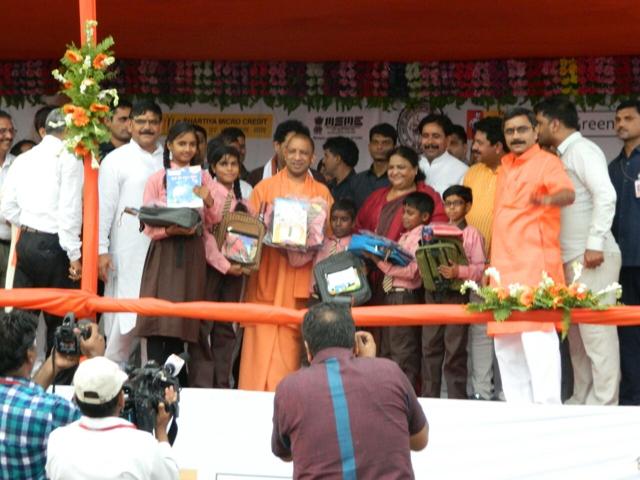 Yogi Adityanath distributes school bags and uniforms among school children. (HT Photo)