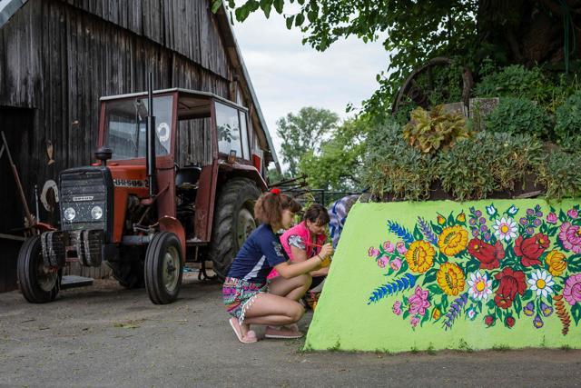 Women painting traditional flower patterns on the wall of a farm building. (AFP) Women painting traditional flower patterns on the wall of a farm building. (AFP)