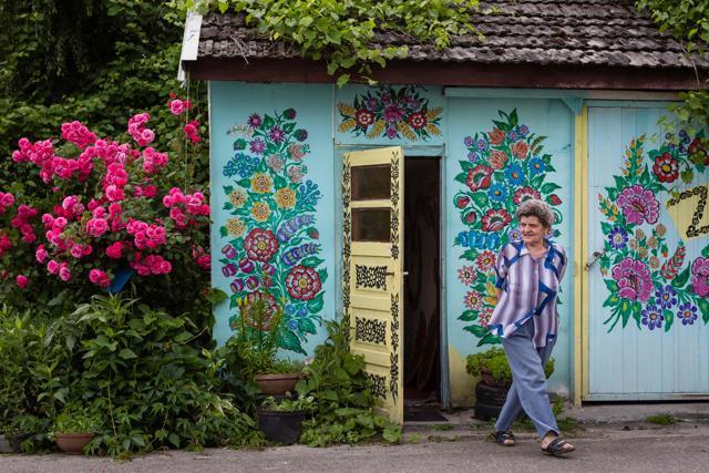 Maria Chlastawa in her yard where the walls of buildings are covered with traditional flower patterns. (AFP) Maria Chlastawa in her yard where the walls of buildings are covered with traditional flower patterns. (AFP)