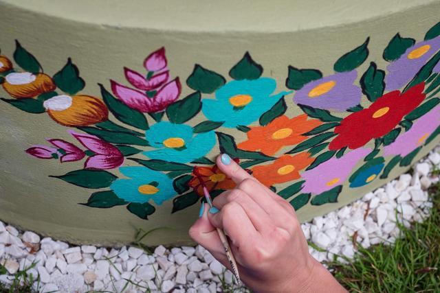A woman painting traditional flower patterns on a well. (AFP) A woman painting traditional flower patterns on a well. (AFP)