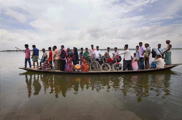 Villagers transported to safety after their houses were submerged in flood waters at Balimukh village in Morigaon district of Assam. (PTI)
