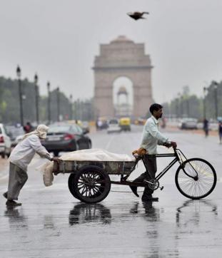 Workers pull a cart near India Gate during rains in New Delhi on July2, 2017.  (PTI)