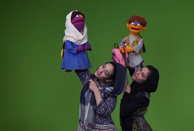 Afghan puppeteers Seema Sultani with new Sesame Street Muppet Zeerak as she performs with colleague Mansoora Shirzad, who is holding Muppet Zari, during a recording at a television studio in Kabul. (AFP)