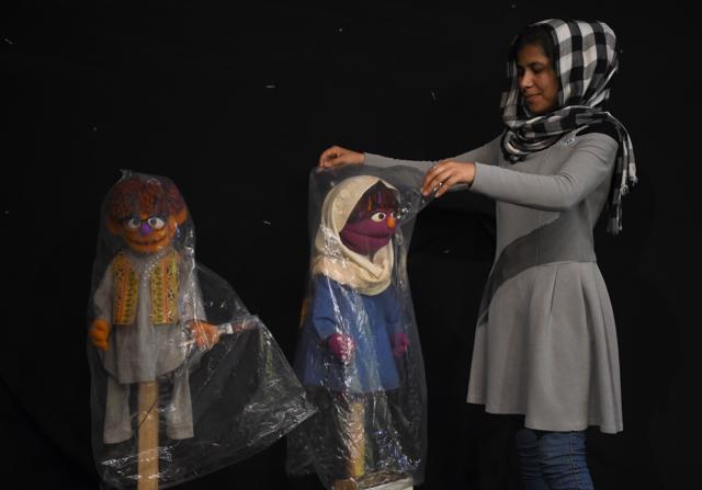 Afghan puppeteer Raziya Nazari covers Zari and Zeerak after a recording at the TV studio. (AFP)