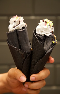 The black ice-cream is mixed with edible charcoal. The charcoal has no peculiar taste but has a grainy texture to it. (IceKraft) The black ice-cream is mixed with edible charcoal. The charcoal has no peculiar taste but has a grainy texture to it. (IceKraft)
