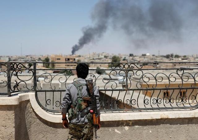 A Kurdish fighter from the People's Protection Units (YPG) looks at a smoke after an coalition airstrike in Raqa, Syria June 16, 2017. (Reuters) A Kurdish fighter from the People's Protection Units (YPG) looks at a smoke after an coalition airstrike in Raqa, Syria June 16, 2017. (Reuters)