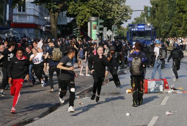 Demonstrators run away after setting a garbage bin afire during a protest on the first day of the G-20 summit in Hamburg, on July 7, 2017. (AP) Demonstrators run away after setting a garbage bin afire during a protest on the first day of the G-20 summit in Hamburg, on July 7, 2017. (AP)