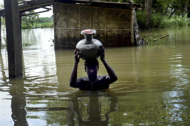 A boy carries fresh drinking water on head as he wades through flooded water at Padder parr village in Karimganj district, Assam on July 7, 2017. (PTI) A boy carries fresh drinking water on head as he wades through flooded water at Padder parr village in Karimganj district, Assam on July 7, 2017. (PTI)
