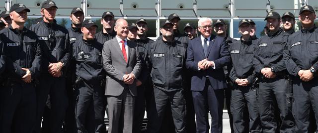German President Frank-Walter Steinmeier (7R) and Hamburg's mayor Olaf Scholz (6L) pose with police entities that worked during the G20 summit in Hamburg, northern Germany, on July 9, 2017.  (AFP)
